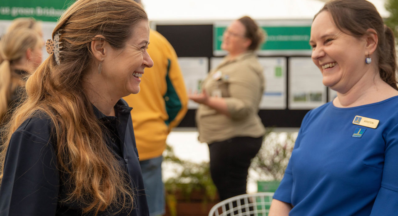 A Council officer speaking with a visitor to a stand at the 2023 Green Heart Fair in Victoria Park.