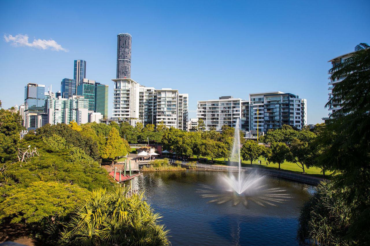 View of Roma Street Parkland lake and fountain with high rise buildings in the background.