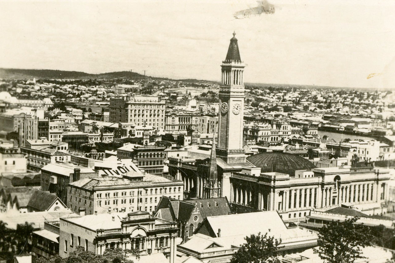 Historical photo with sepia tones of Brisbane City with Brisbane City Hall as focal point.