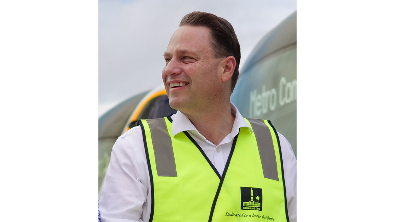 An image of Lord Mayor, Adrian Schrinner, looking to the left in a yellow high-vis vest.