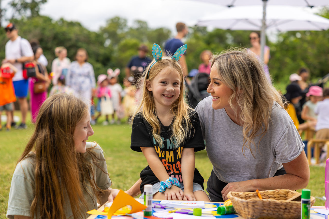 A mum with two children at craft stand at a family-fun day at Victoria Park.