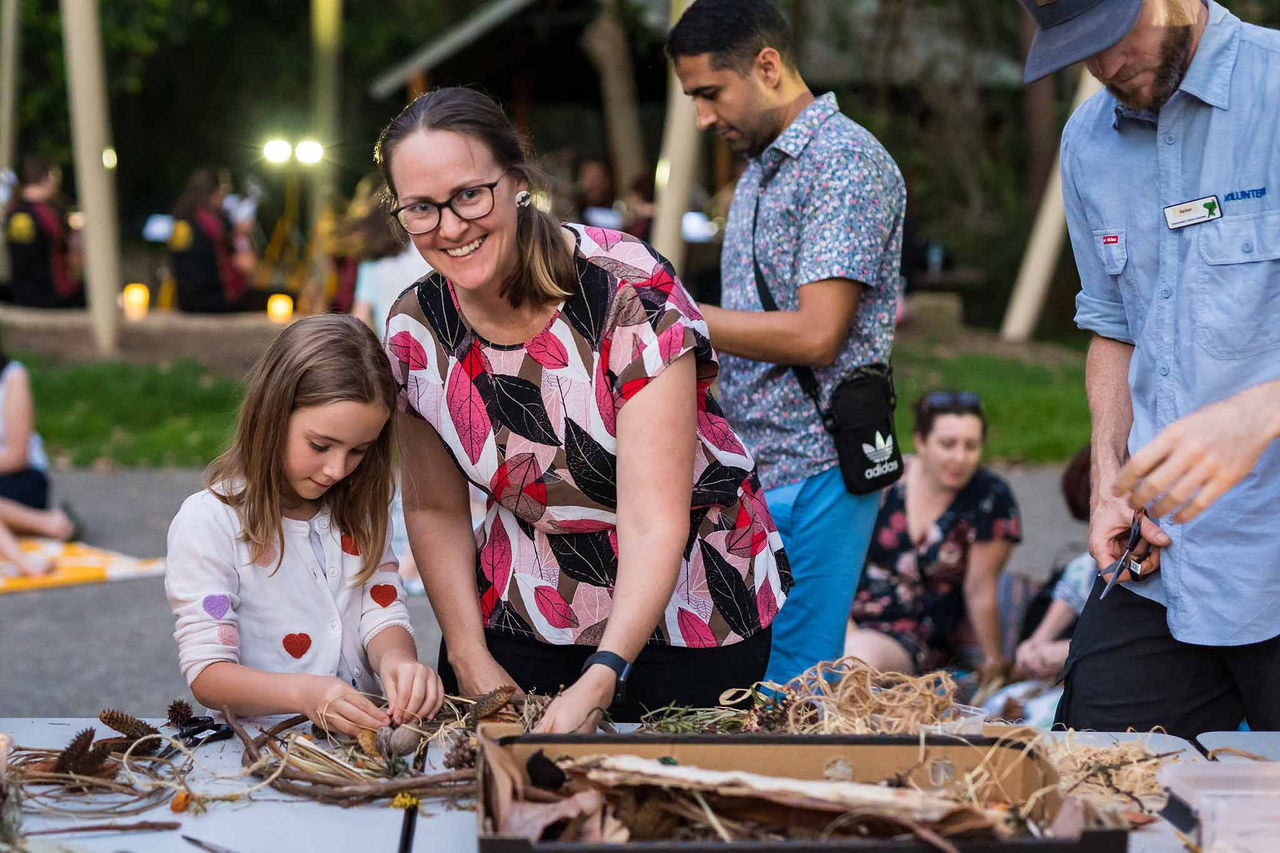 A mother and daughter doing craft with natural materials at Bush Christmas.