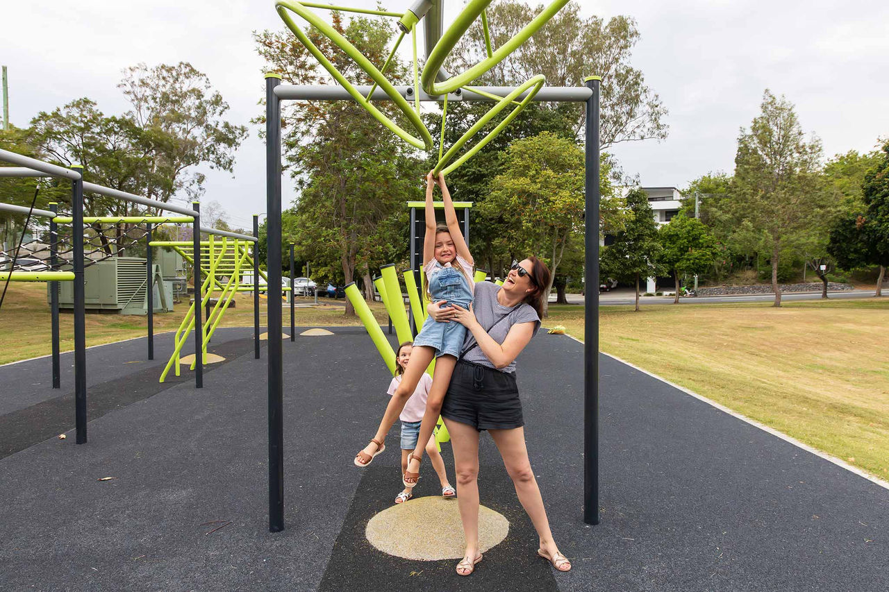 Mother and children climbing on ninja course equipment at Guyatt Park.