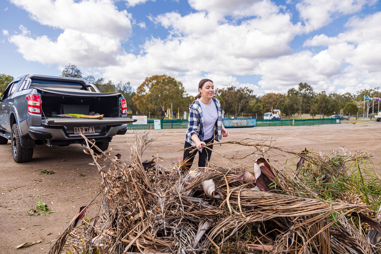 Woman disposing of green waste from ute tray at Chandler Resource Recovery Centre.