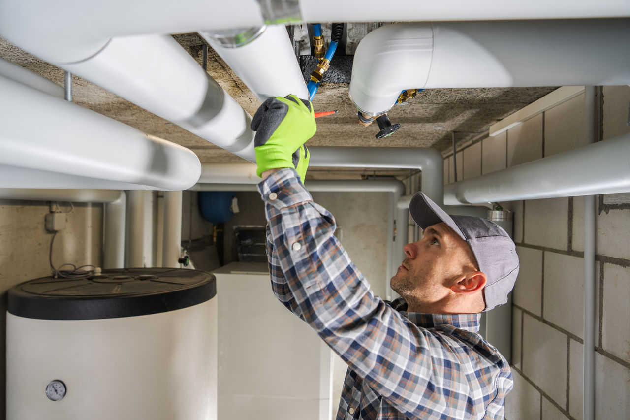 Professional plumbing contractor finishing sanitary pipeline installation.