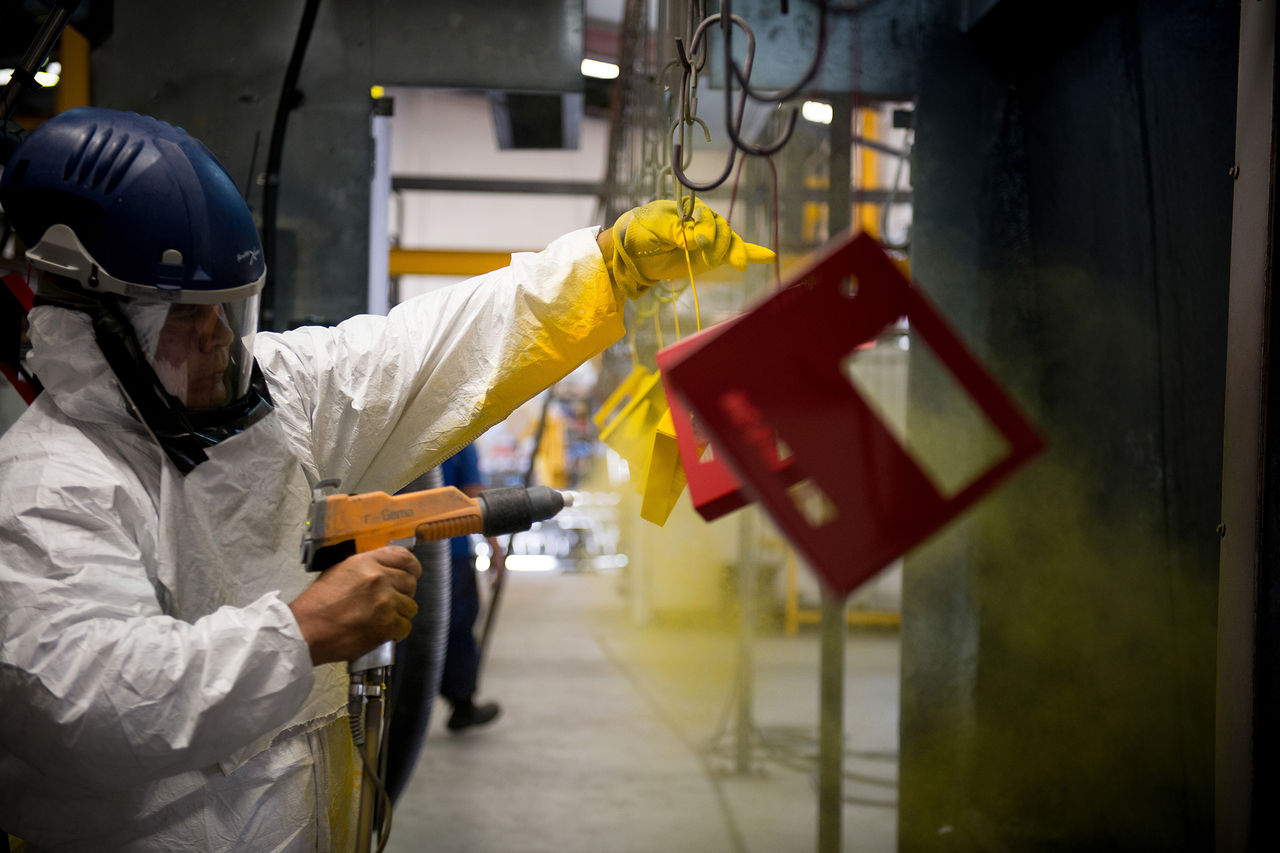 Worker undertaking surface coating in an industrial building.