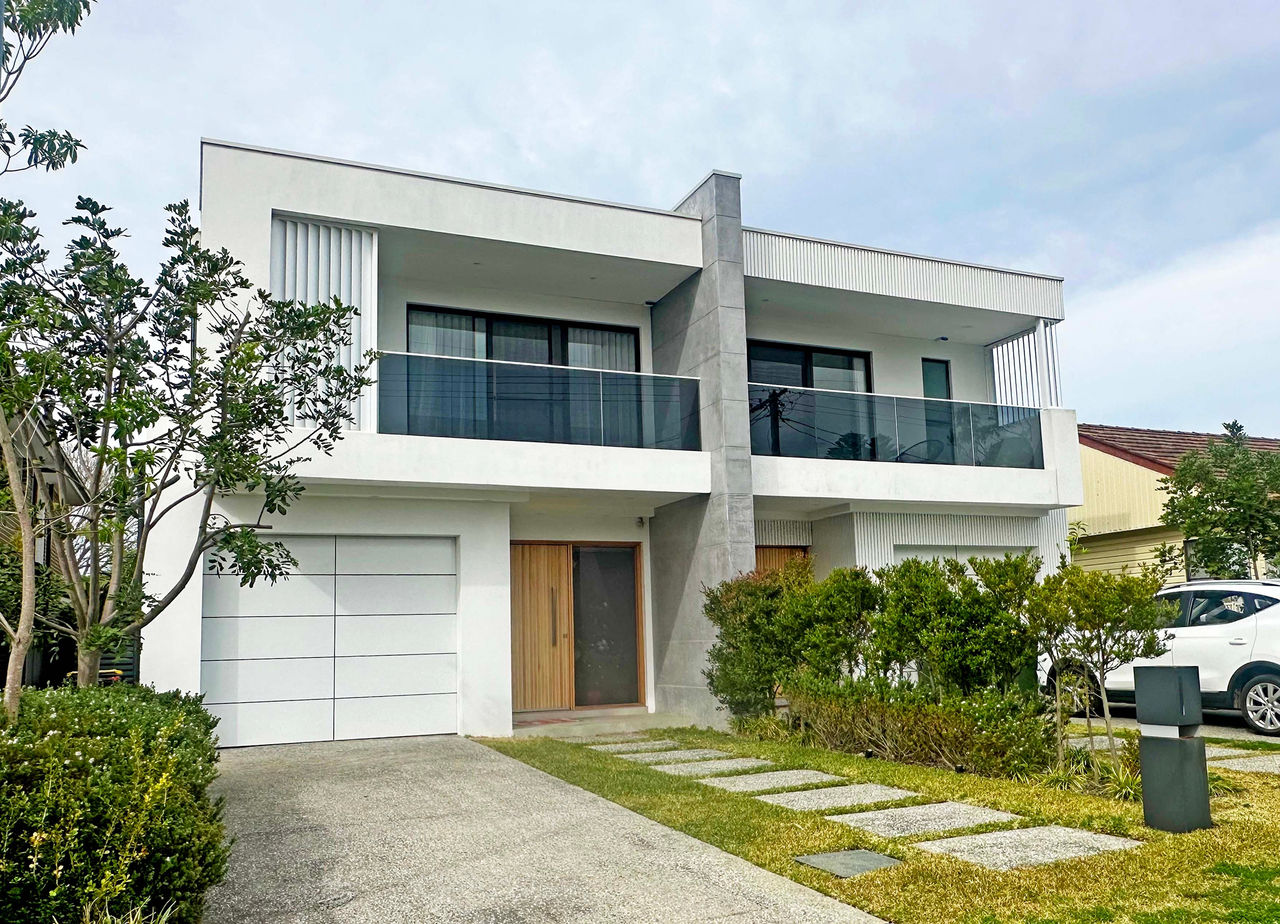 This image shows a modern looking dual occupany two driveways and a flat roof.