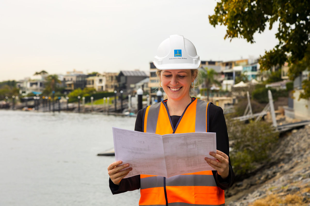 Female enginner on a development site looking at plans.
