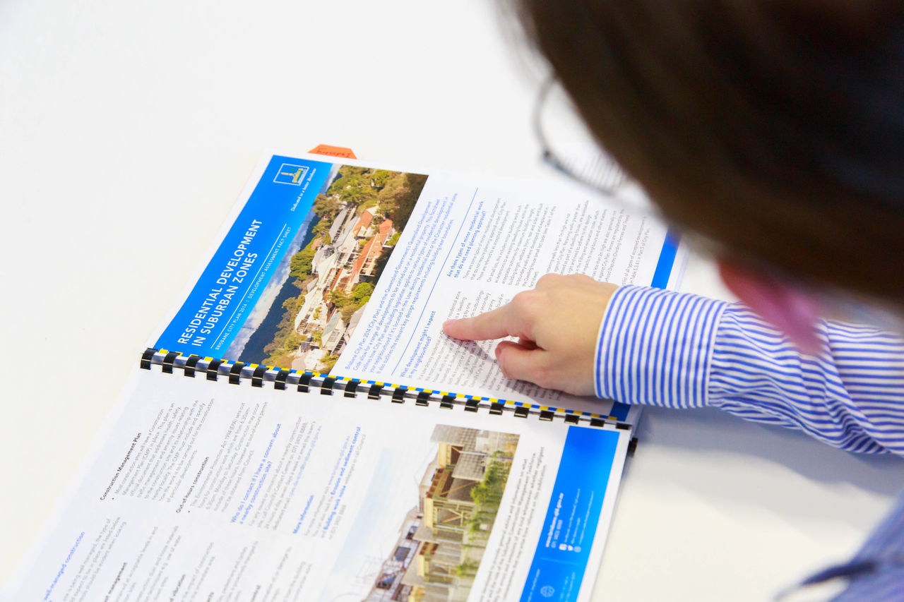 A close up of a female Council officer's hand pointing to a document at a Talk to a Planner event.