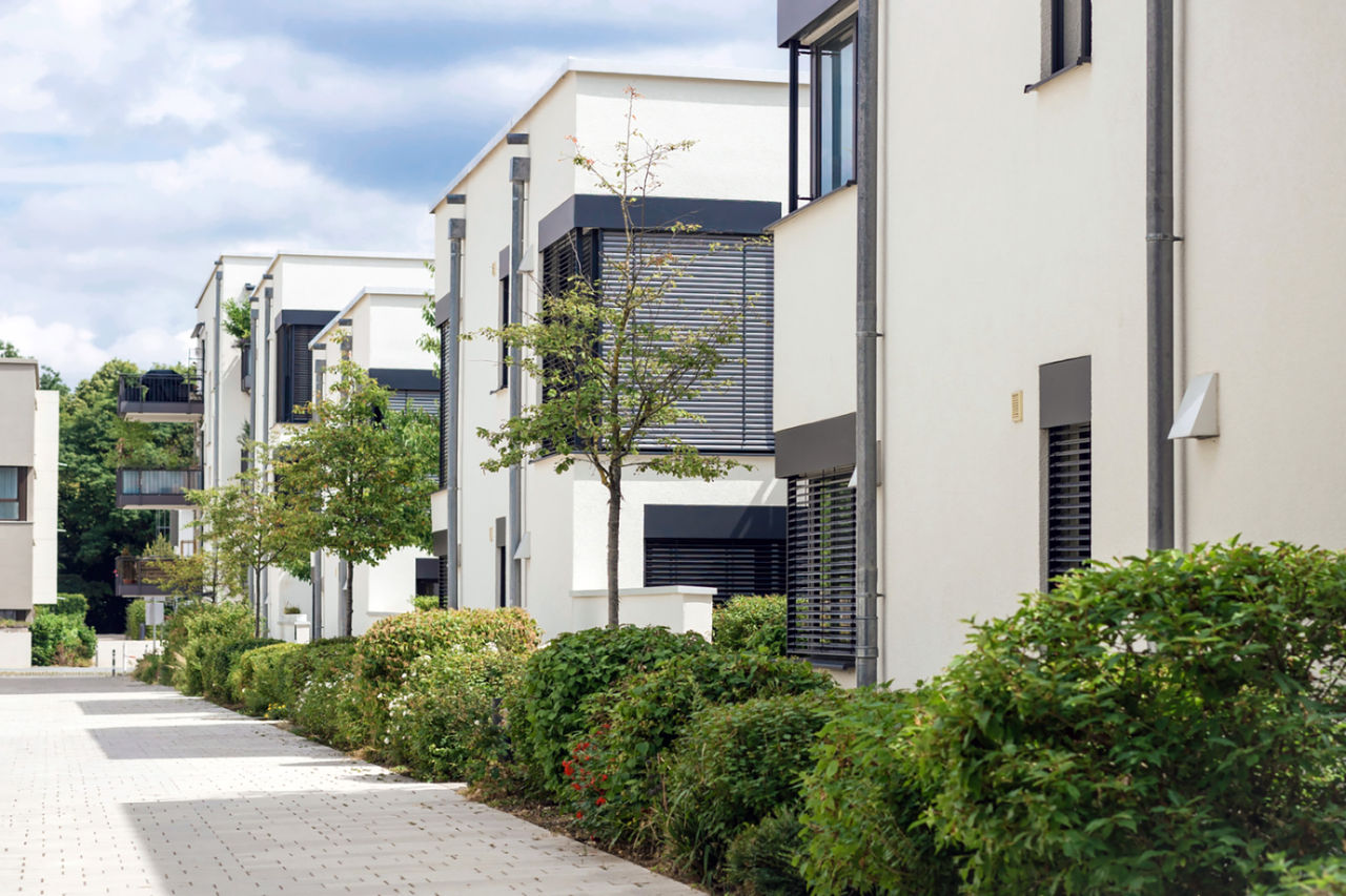 Part of a streetscape showing modern multi-story multi-unit dwellings.