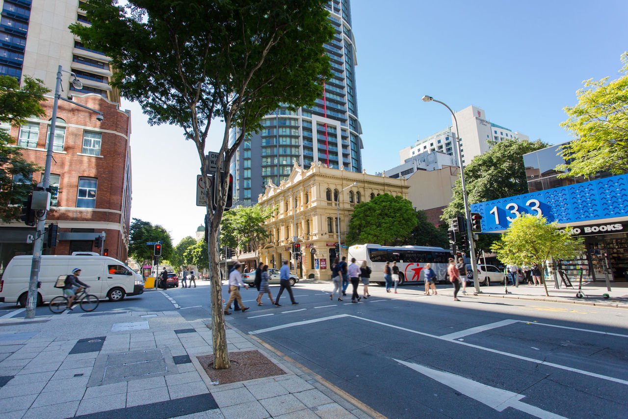 People cross the road at a set of traffic lights in the city.