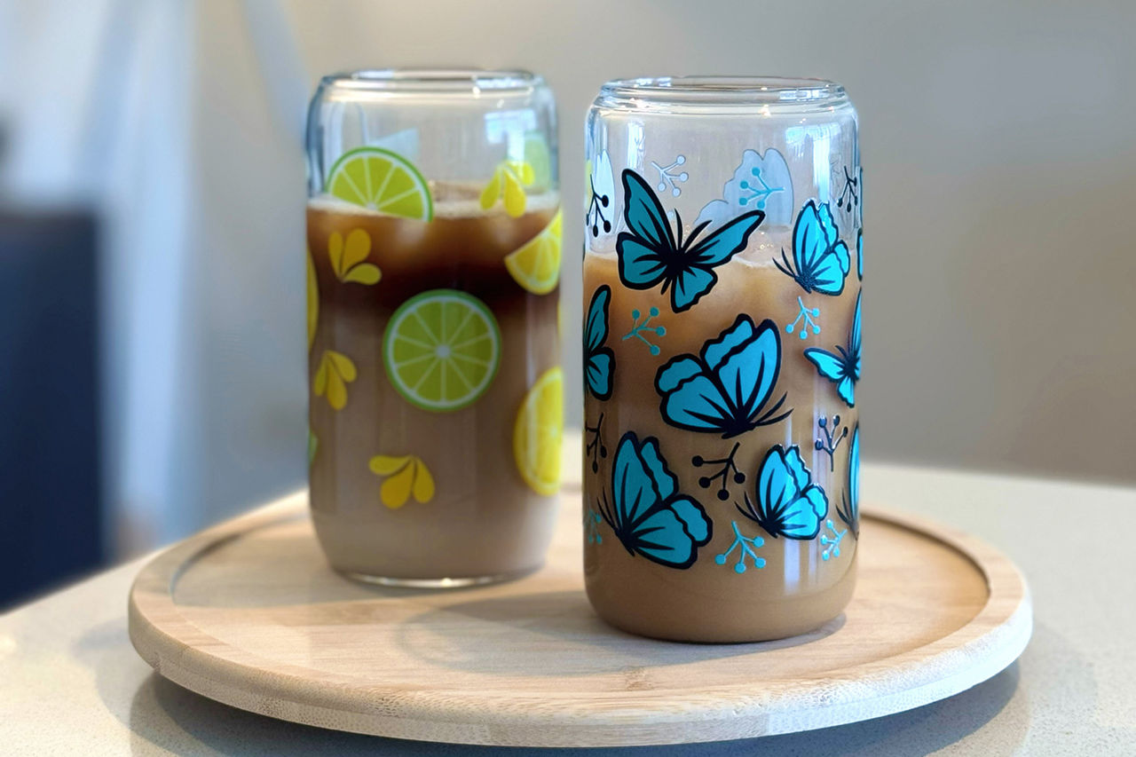 Two drinking glasses from Sips Sense - one with lemons and one with butterflies.