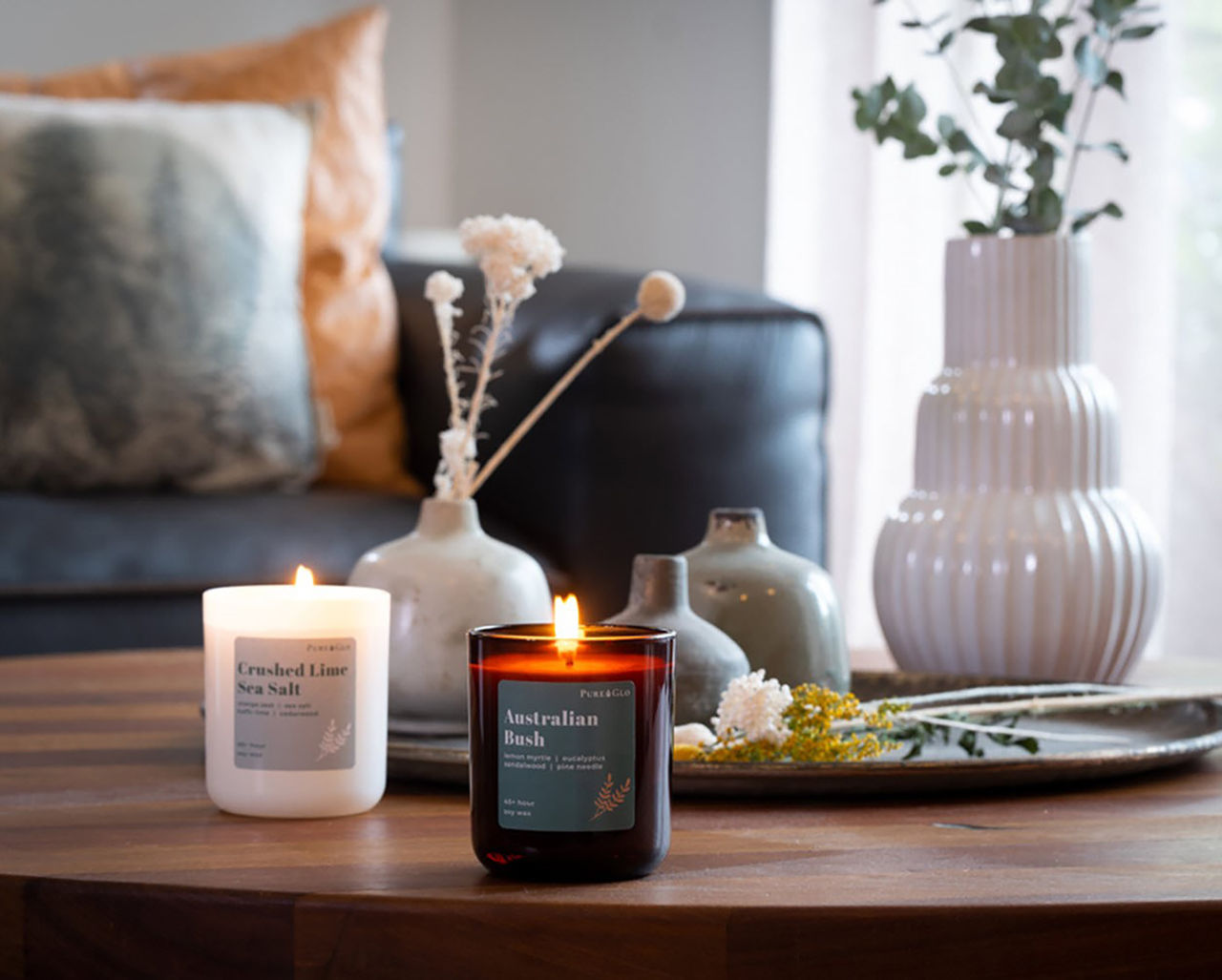 A lounge table set up with Pure Glo candles and other table decorations.