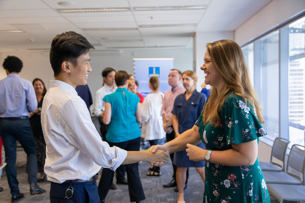 Two business people meeting at at networking event with a handshake.