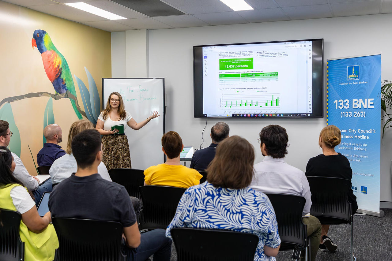 A woman speaking to an audience seated in chairs at the Suburban Business Hub.
