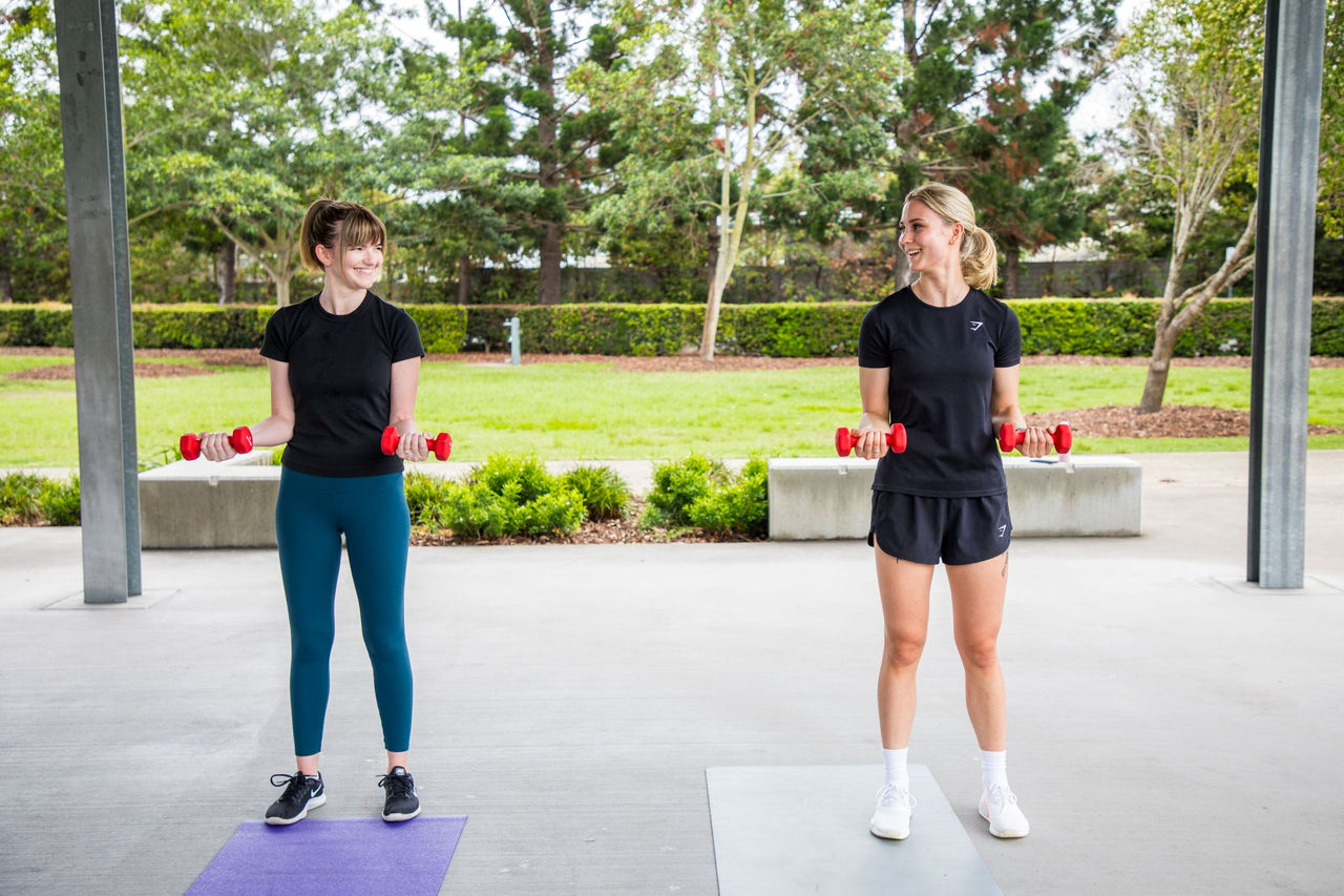 Two people holding hand weights during a fitness class.