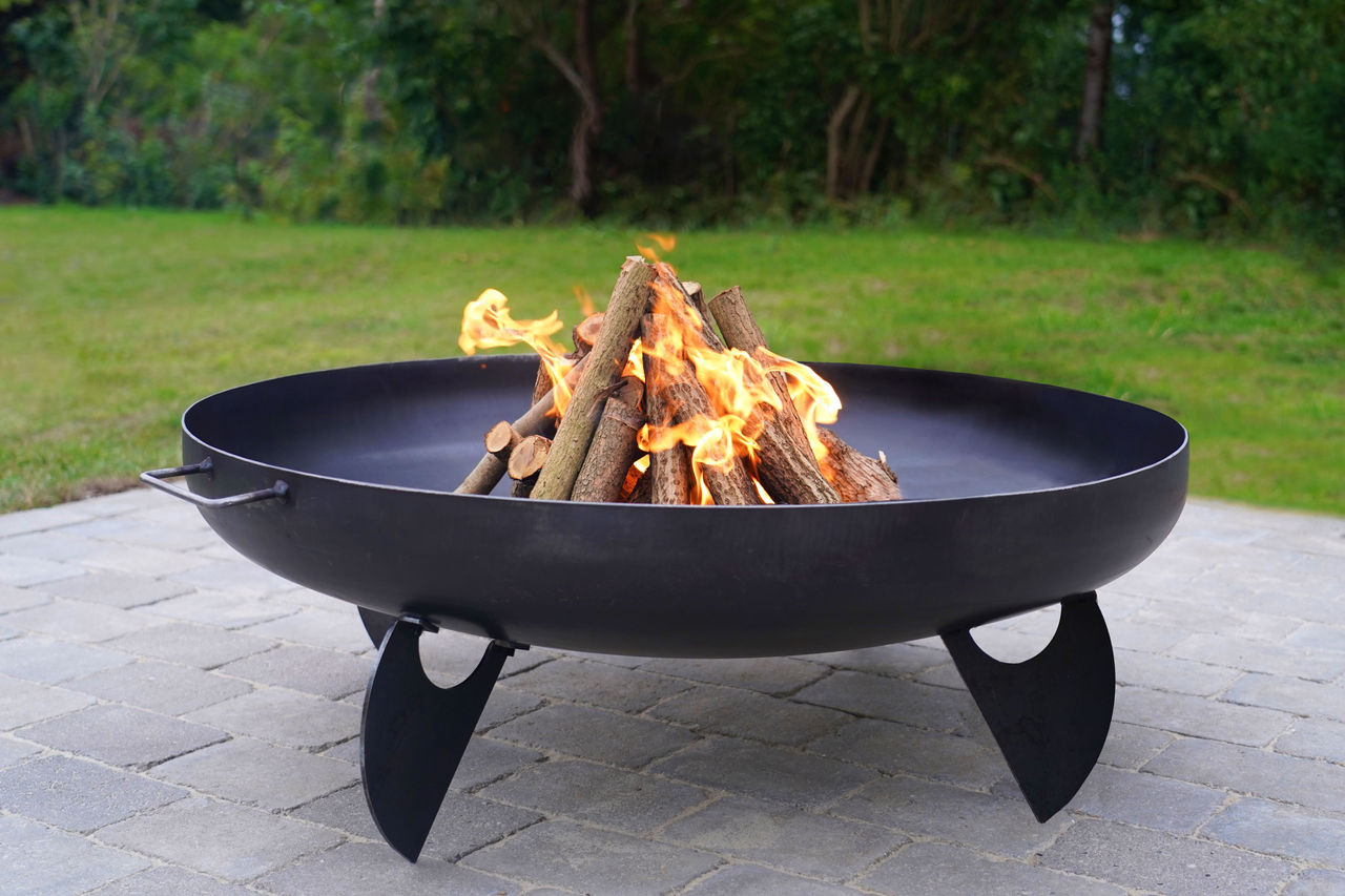 Iron fire pit and burning fire in a garden.