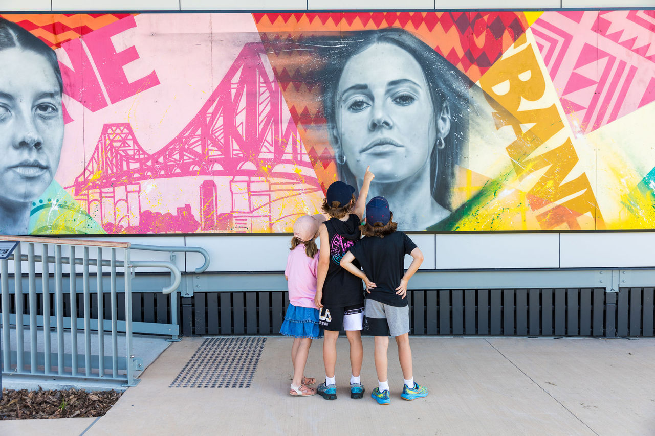 Group of 3 kids looking at a mural in Nudgee Recreation Reserve.