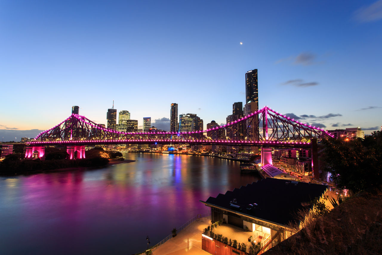 Story Bridge lit up in pink at twilight.