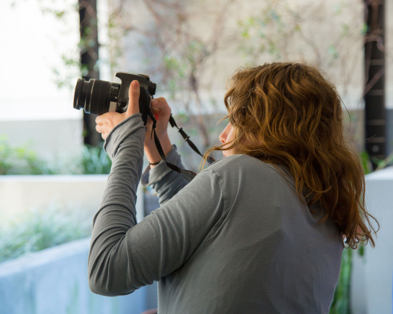 Female teenager shooting with an digital SLR camera in a photography workshop at Visible Ink.