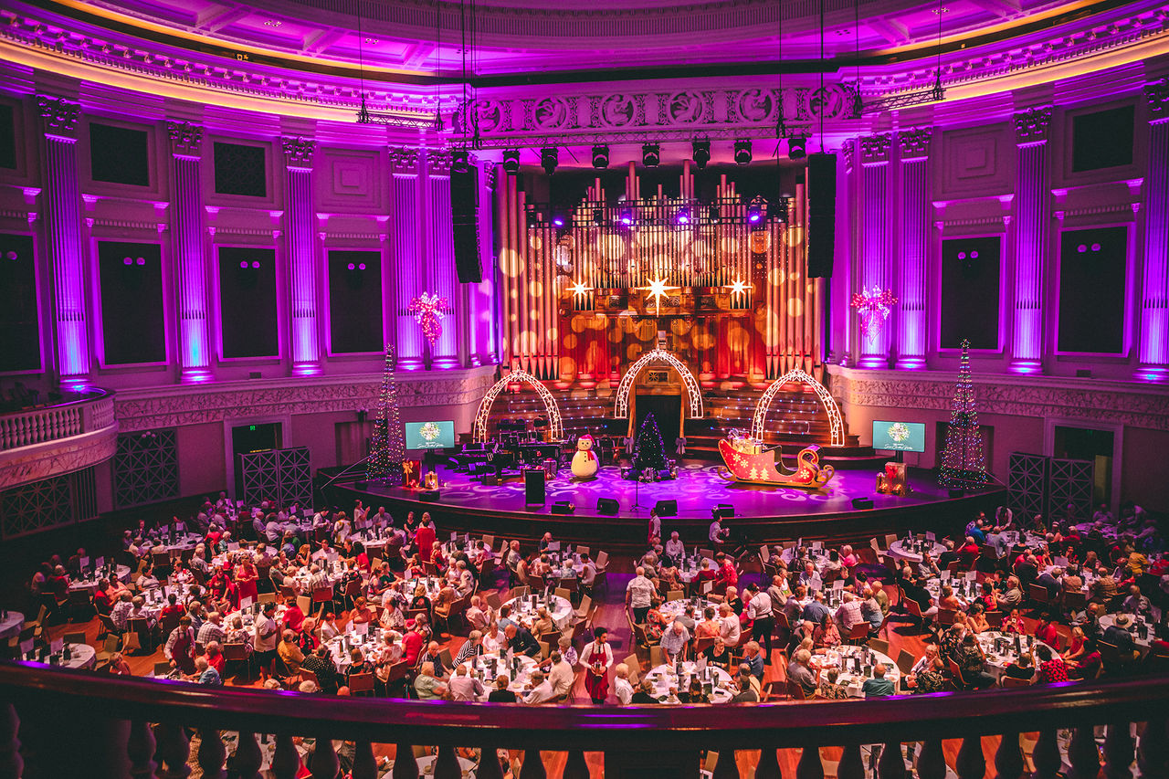 View from balcony across auditorium floor to stage at Lord Mayor's Seniors Christmas Parties, Brisbane City Hall.