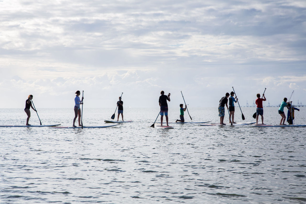 Group of young people participating in a paddleboarding event.