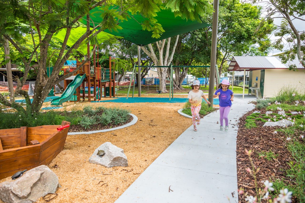 Young girls ruuning along a path at Fallon Park playground.