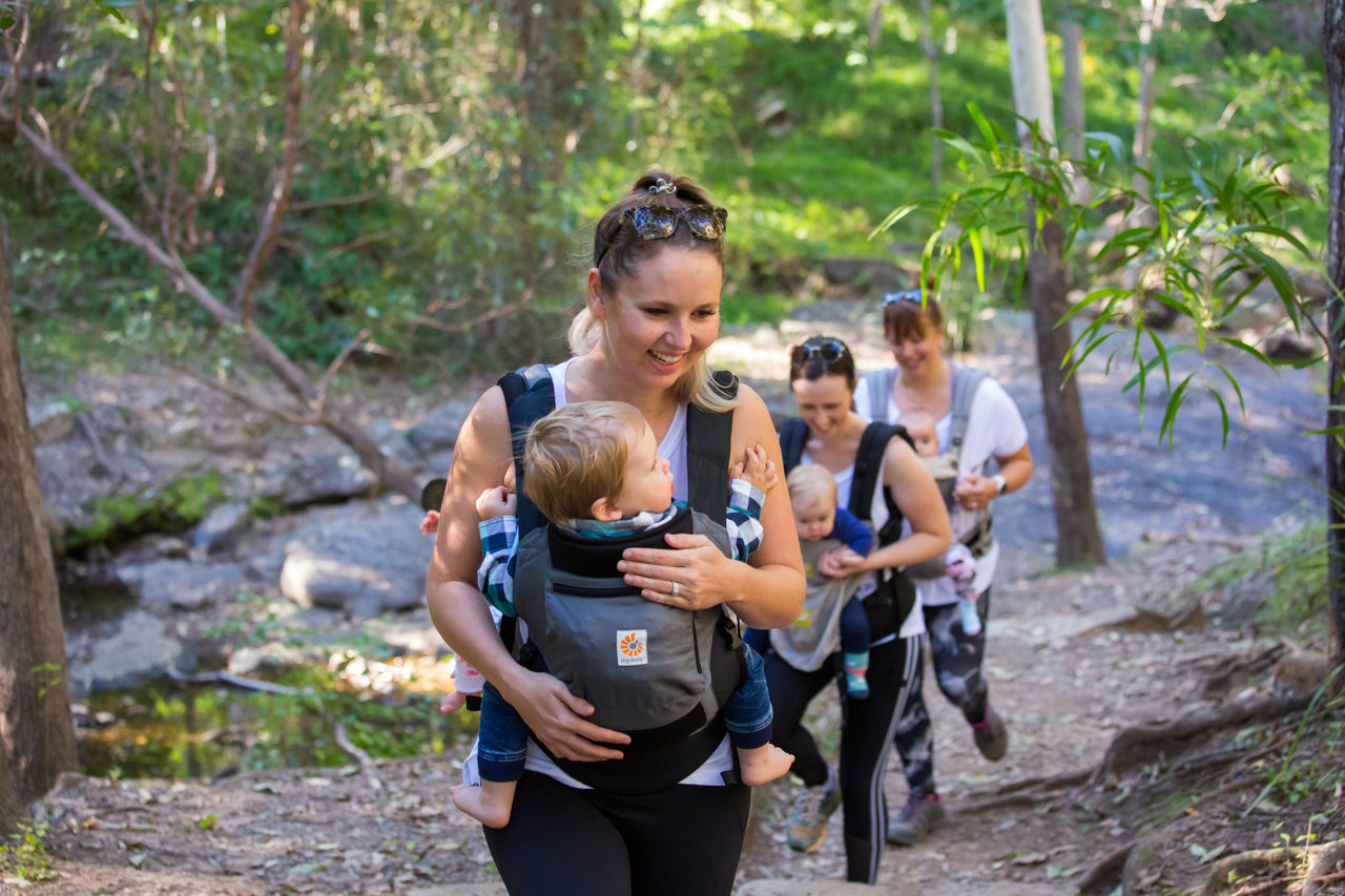 3 women walking with babies up a hill track at Mt Coot-tha Reserve.