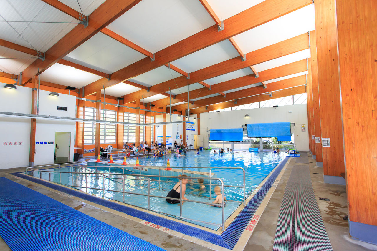 Mother and son on ramp of 25-metre indoor programs pool at Colmslie Aquatic Centre. Other people in background