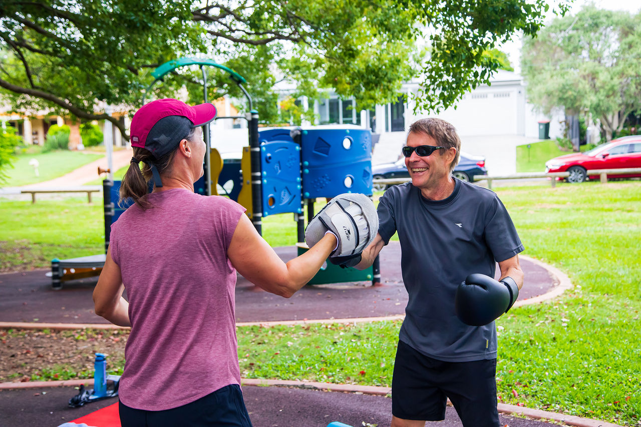 Two people boxing for fitness in a park.