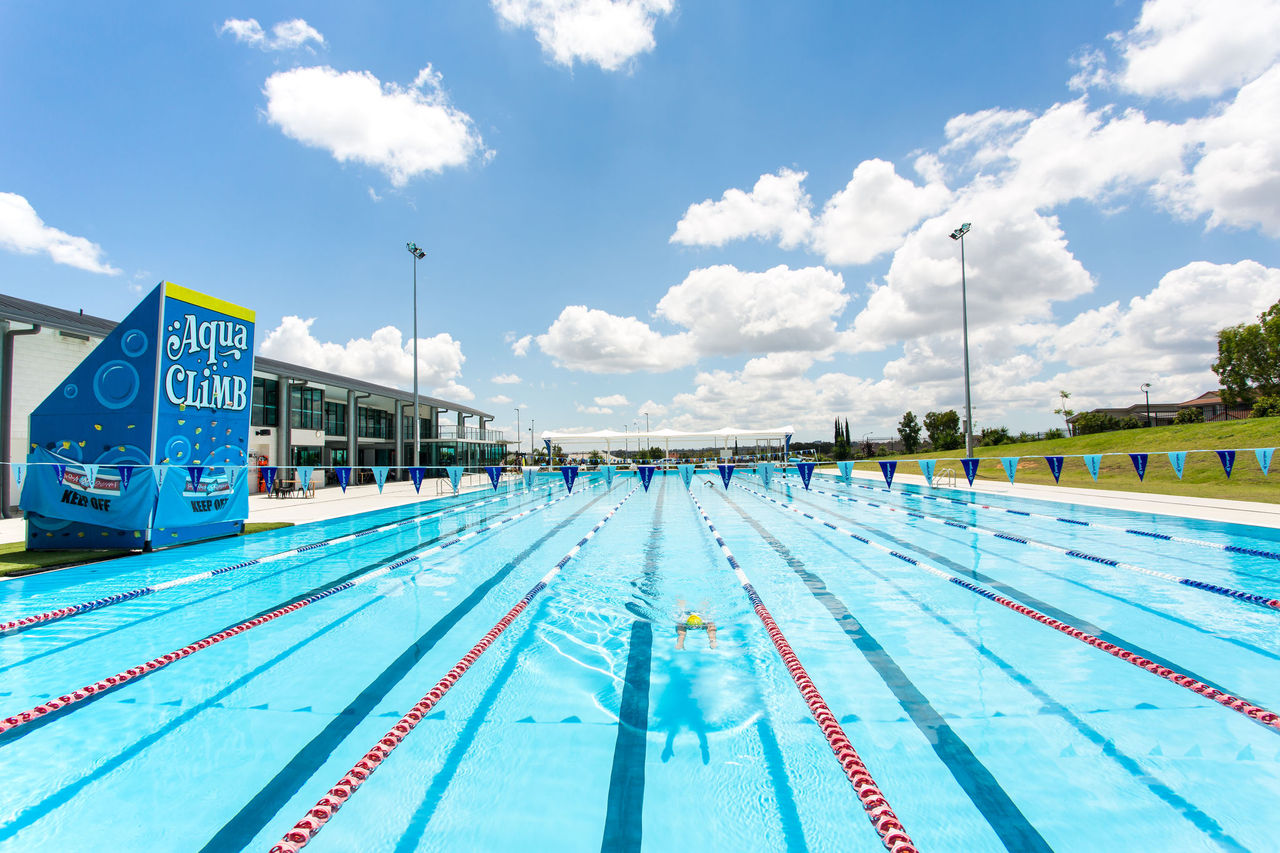 Lap swimmers at Parkinson Aquatic Centre. Aqua Climb structure on left side of pool.