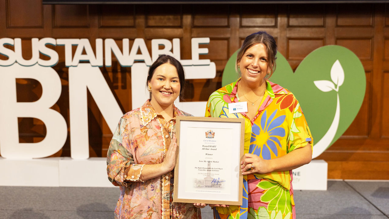 Issy and Lana from Love Me Again Market holding the All-star Awar at the 2025 WasteSMART Brisbane Awards.