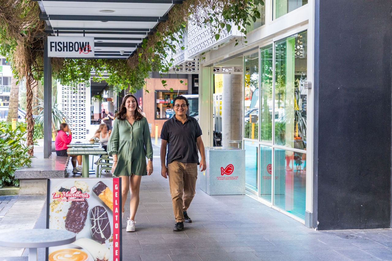 Couple walking through South City Square at Woolloongabba.