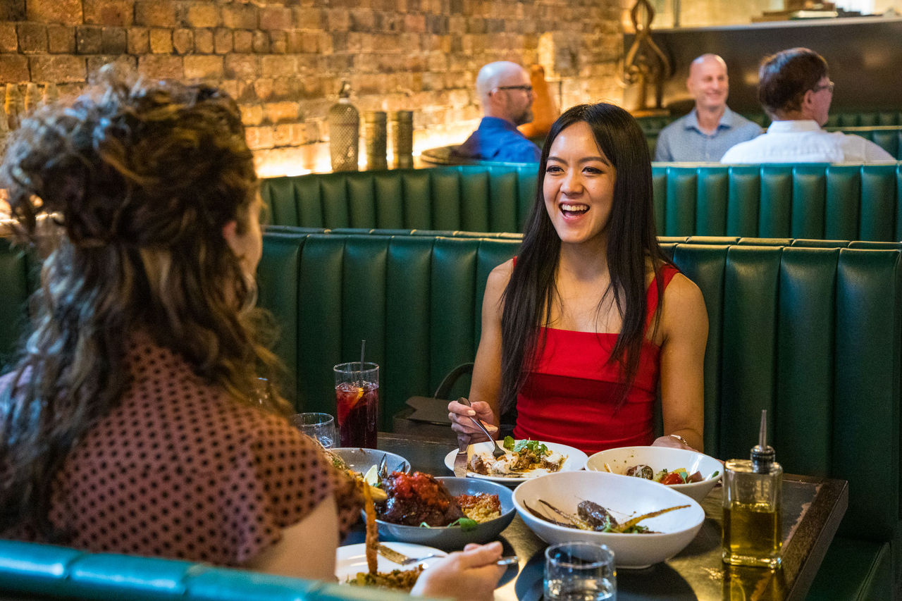 Two women eating in a restaurant in the Caxton Street precinct.