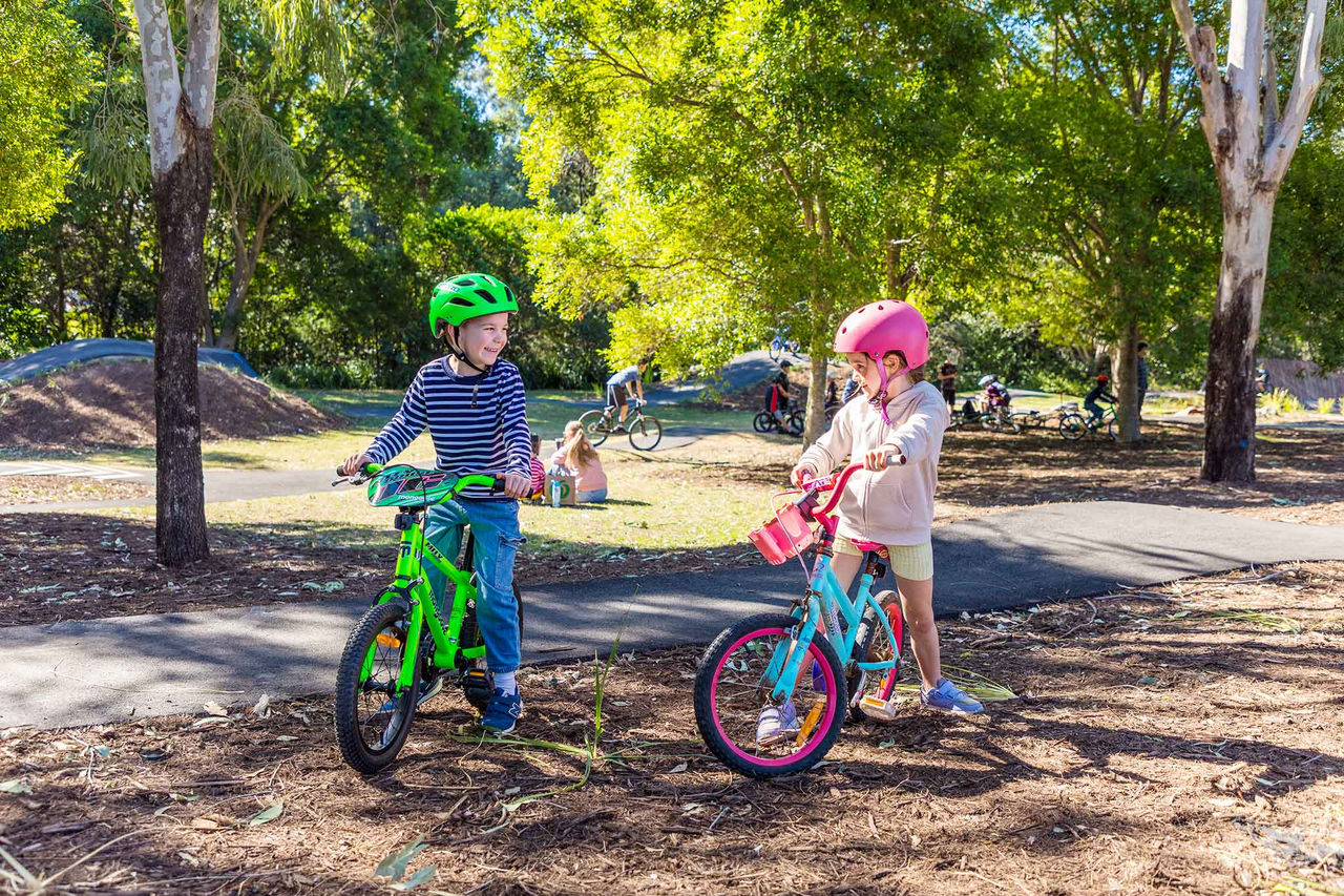 Two young children on small bikes on the multi-use riding track at Glindemann Park.