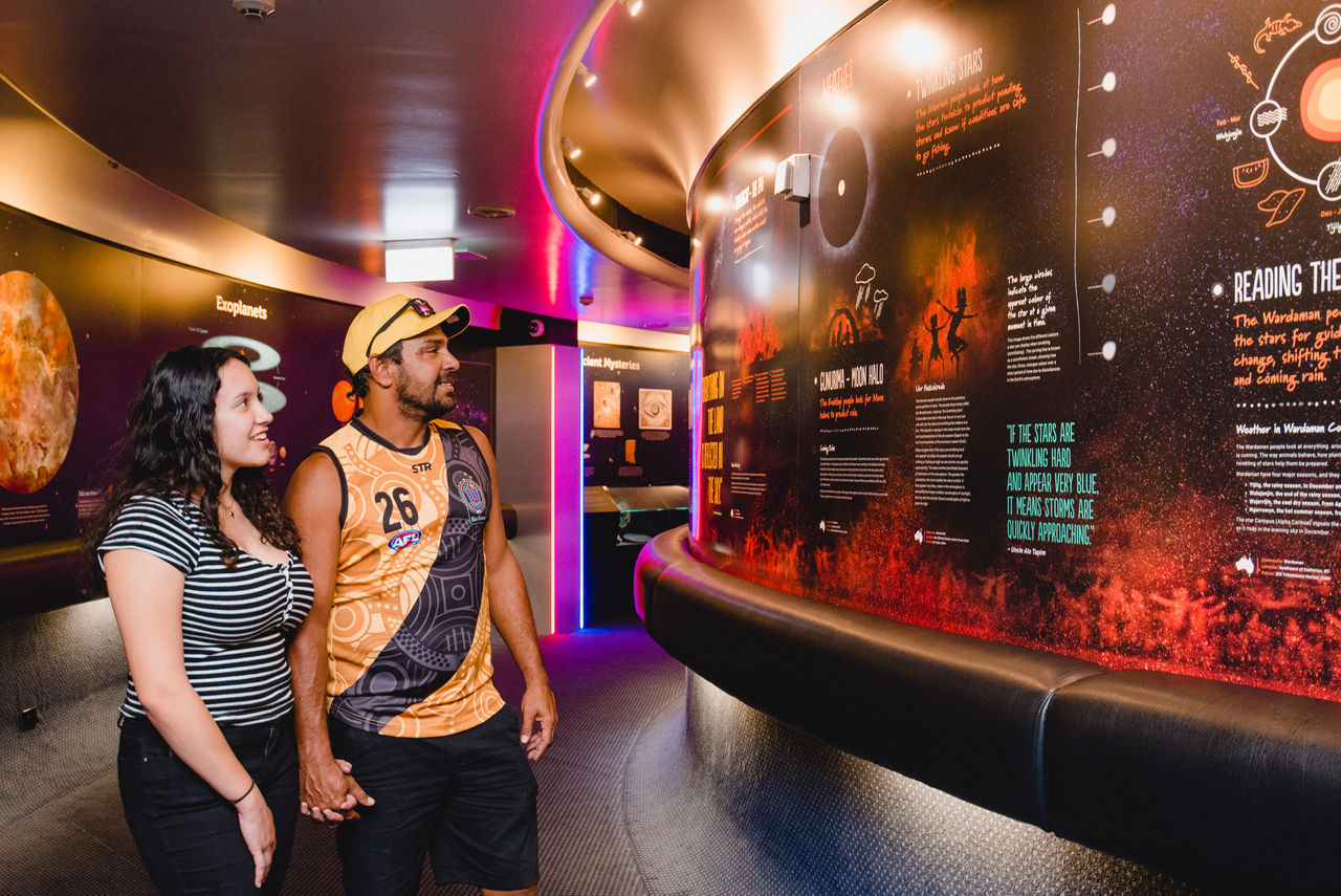 Couple looking at Skylore: Aboriginal and Torrest Strait Islander Astronomy exhibit at the Sir Thomas Brisbane Planetarium.