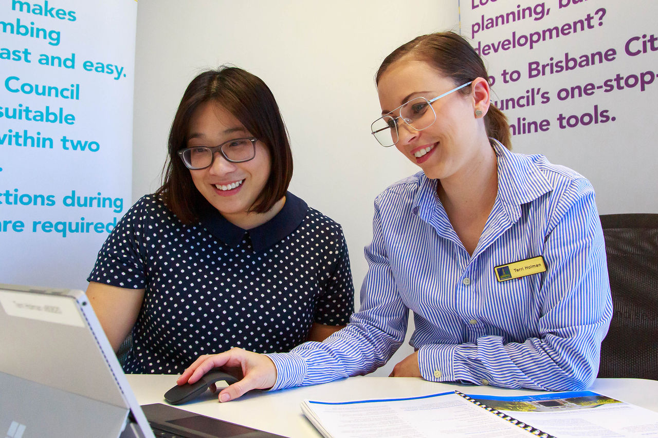 Two smiling women looking at the computer 