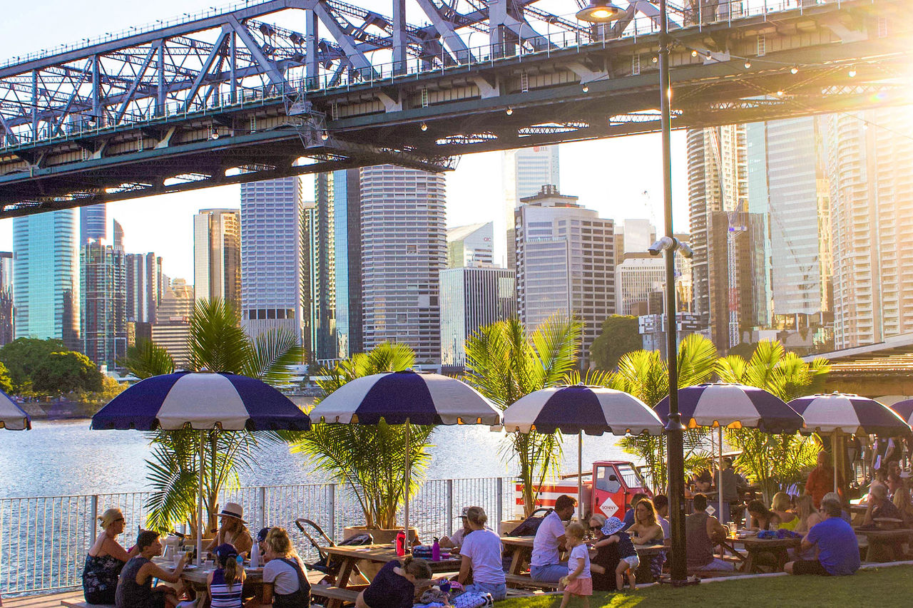 Outdoor diners at Howard Smith Wharves with Story Bridge in background.