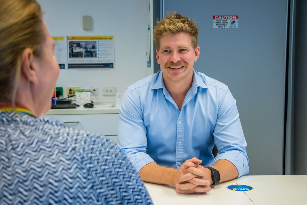 Male and female office workers in a Council meeting room.