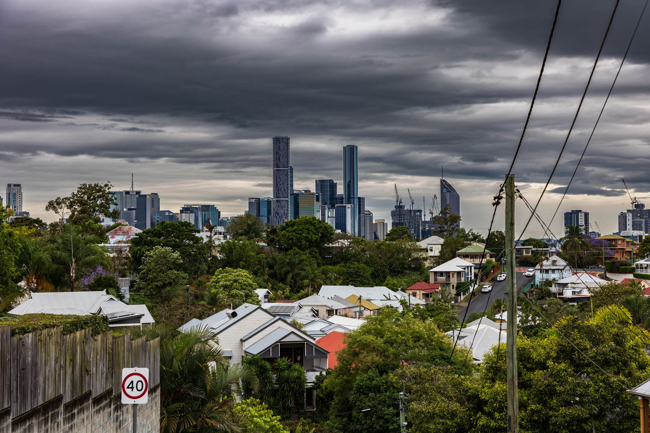 Dark grey storm clouds over the Brisbane City skyline viewed from the top of a Paddington street