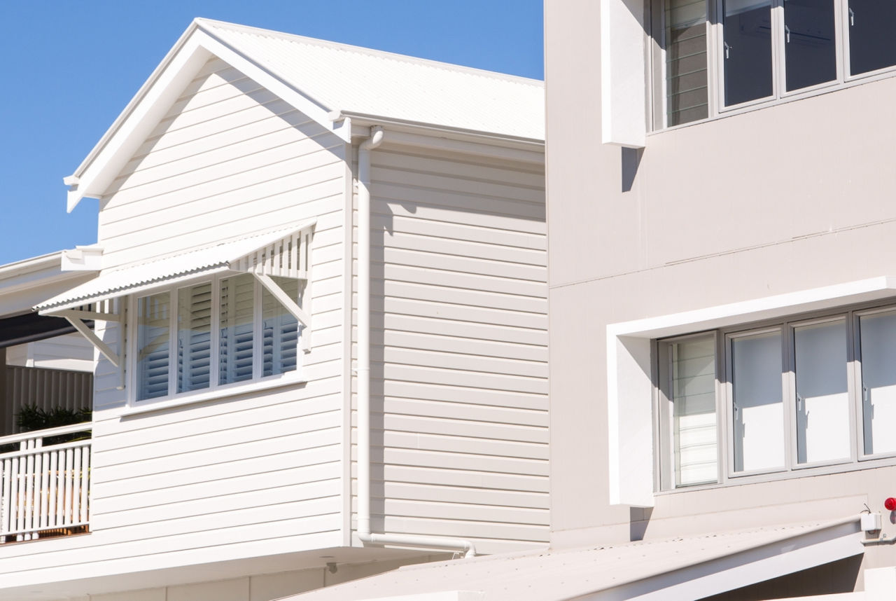 Two modern two-storey houses with white and neutral tones.