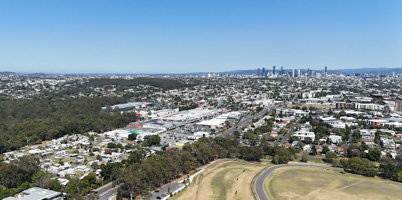 Aerial view of Brisbane suburbs looking towards the city skyline in the background.