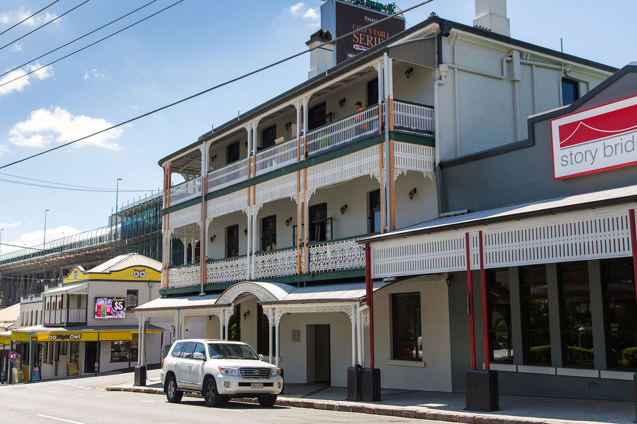 The Story Bridge Hotel as seen from the street with a car parked outside.