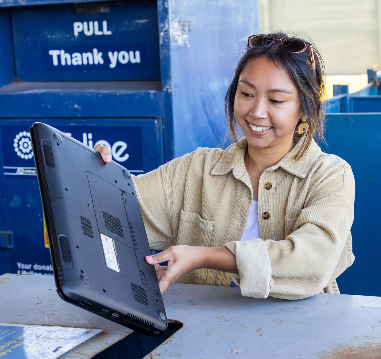 Woman recycling her laptop at a Council resource recovery centre.