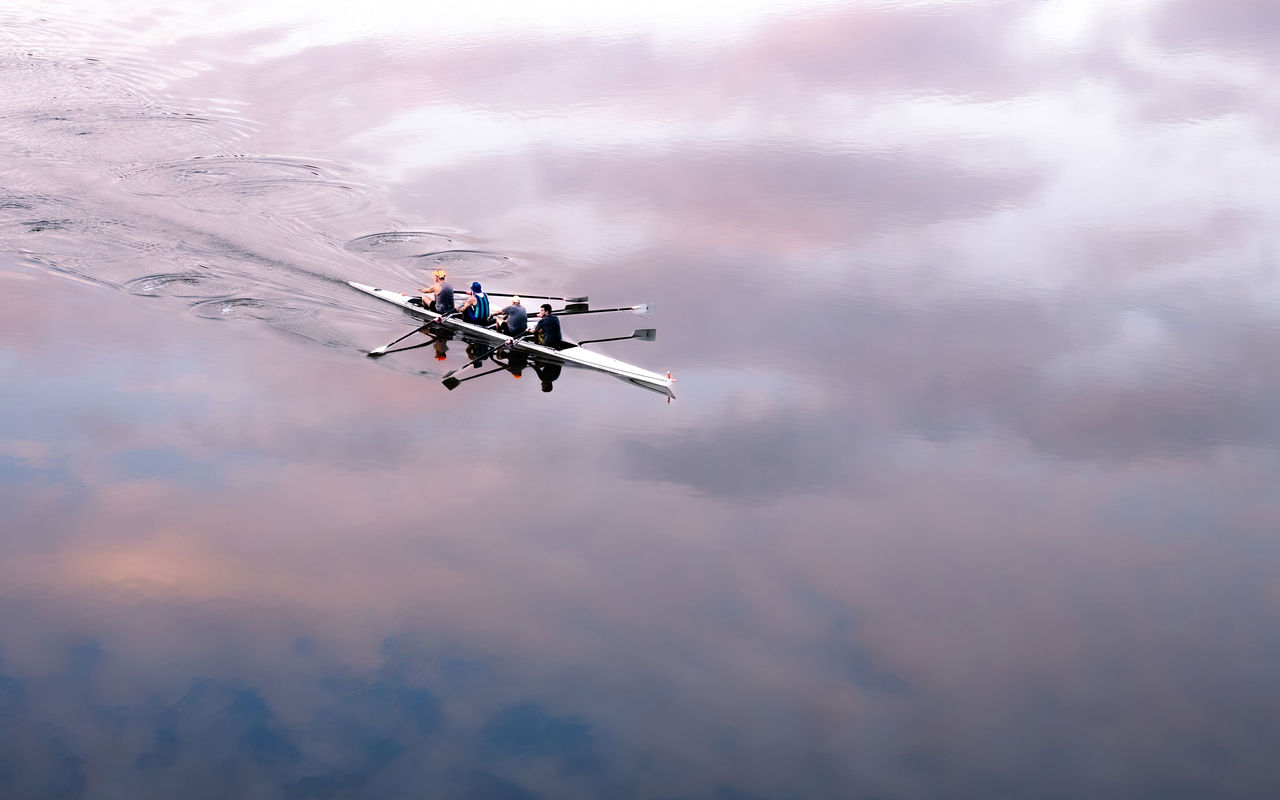 LMPA 2026 Peoples Choice Finalist - Nigel Cowdery - Morning Exercise on Reflected Waters. A four team member rowing group rowing along the Brisbane River with clouds reflected on the water.