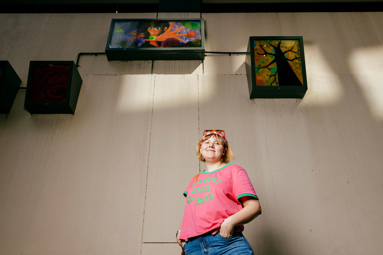 Artist Grace Lindeman in front of her artworks for the AMPLIFY ME! Outdoor Gallery exhibition.