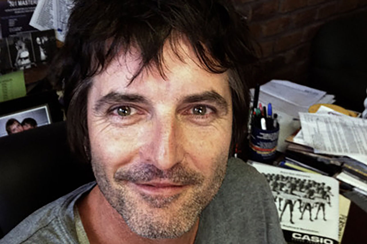 Close-up image of face of John Mullen at a desk.