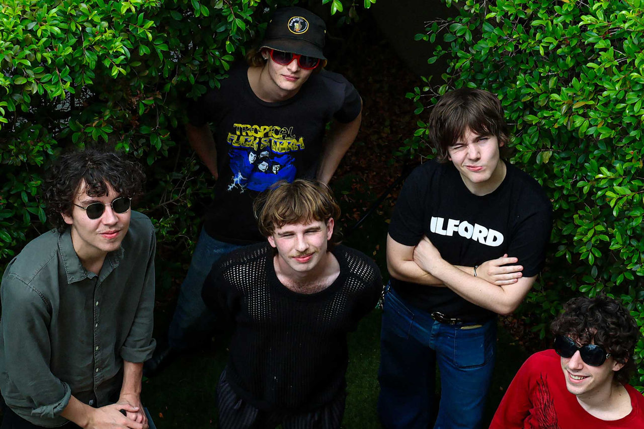 Miss Mardy band members - finalists in The QUBE Effect 2026 - photographed in front of a green shrub.