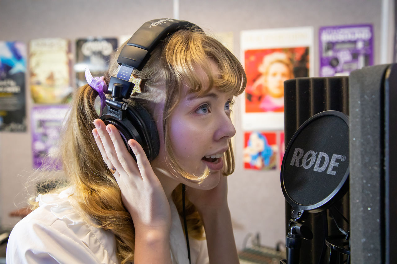 Young lady singing with a microphone.