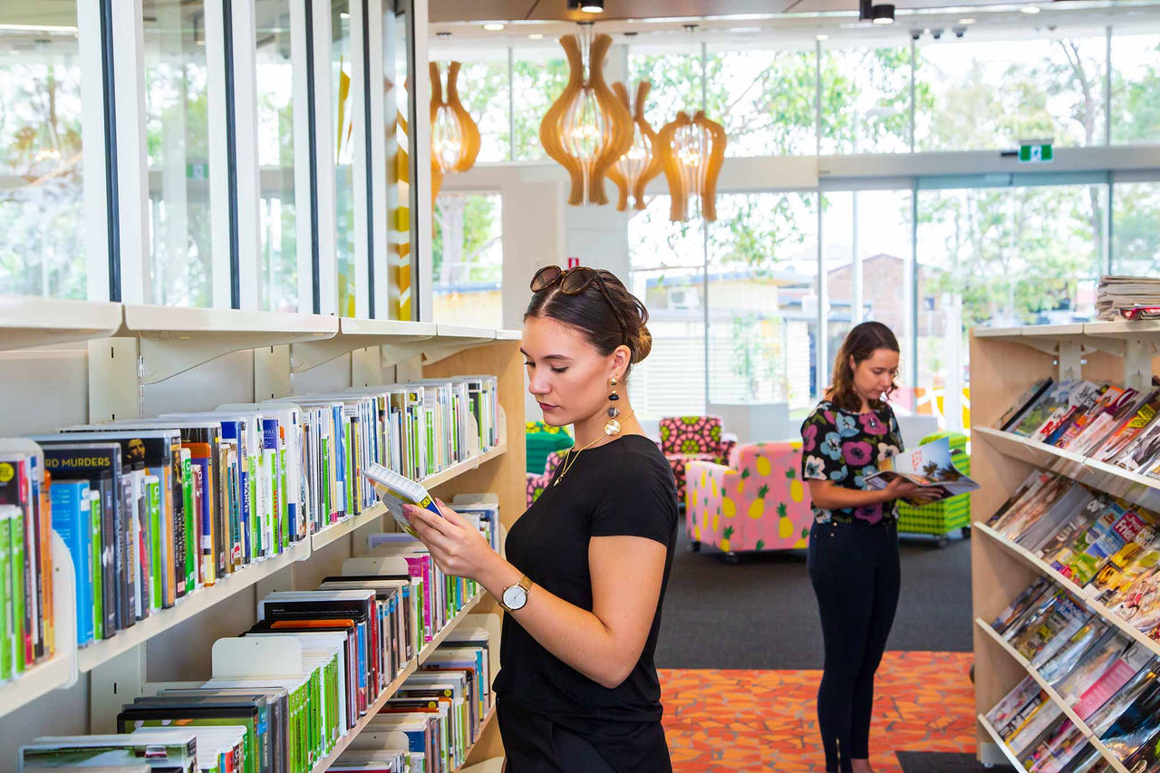 Two women browing the book shelves at Bracken Ridge Library.